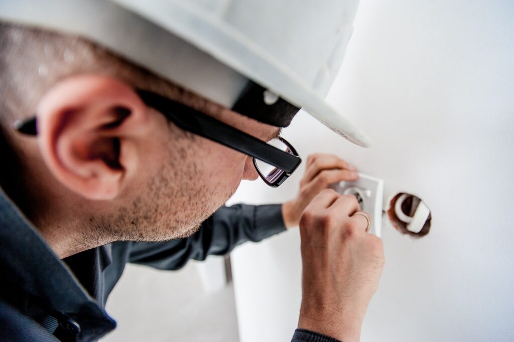 Image of an electrician fixing a wall switch